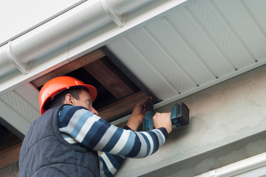 Man repairing soffit Man repairing soffit