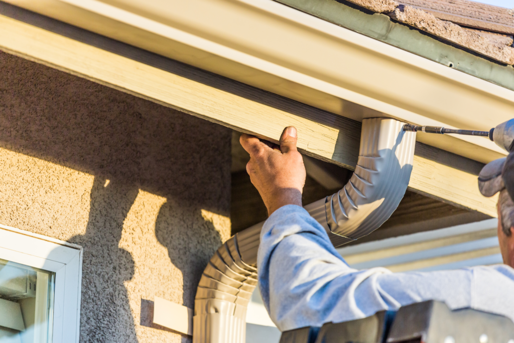 Man repairing fascia on a house